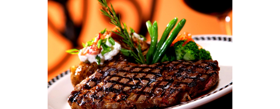 bad website steak house, picture of a delicious looking steak next to asparagus and vegetables