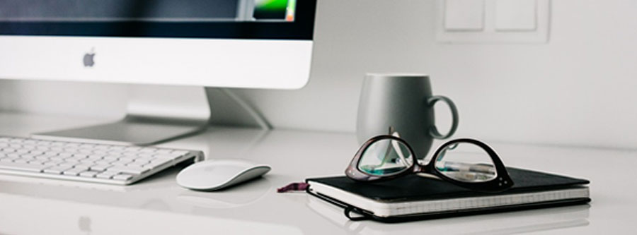 picture of a imac in the background with note pad in the foreground and glasses sitting on top of it on top of a computer design for website design