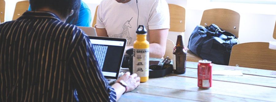 picture of some men sitting on laptops with drinks next to them for what is website design